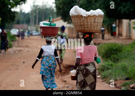 Afrikanische Frauen balancieren Körbe auf dem Kopf auf dem Weg zum Markt. Benin. Stockfoto