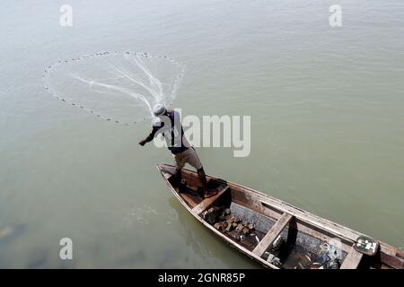 Afrikanischer Fischer wirft das Netz auf traditionelle Weise in den Fluss. Benin. Stockfoto