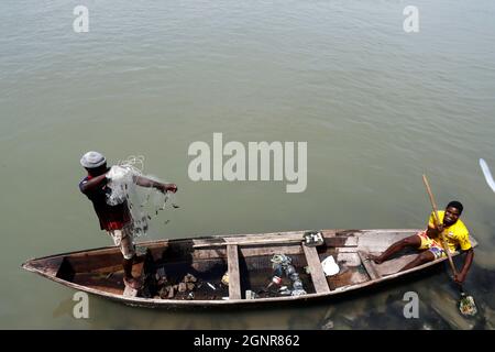 Afrikanischer Fischer wirft das Netz auf traditionelle Weise in den Fluss. Benin. Stockfoto