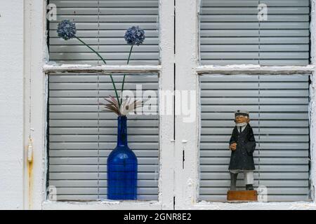 ÅNA-SIRA, NORWEGEN - SEPTEMBER 08. Ein Seefahrer, der zusammen mit einem Blumentopf im Fenster steht. Stockfoto