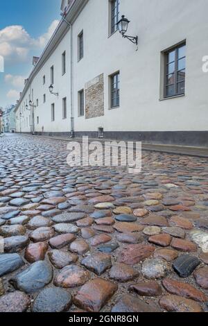 VILNIUS, LITAUEN – 2020. MÄRZ 06. Eine enge Straße mit zwei gelagerten Häusern und einer gepflasterten Straße in der Altstadt von Vilnius. Stockfoto