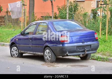 Das beschädigte Auto steht auf Platten Reifen auf dem Parkplatz. Ausschuss. Stockfoto