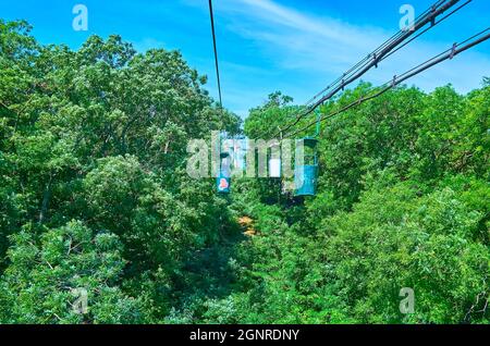 Der Hügel, bedeckt mit üppigem grünen Wald mit den alten Kabinen der Seilbahn von Odessa, die vom französischen Boulevard in der Oberstadt zur Otrada Bea fährt Stockfoto