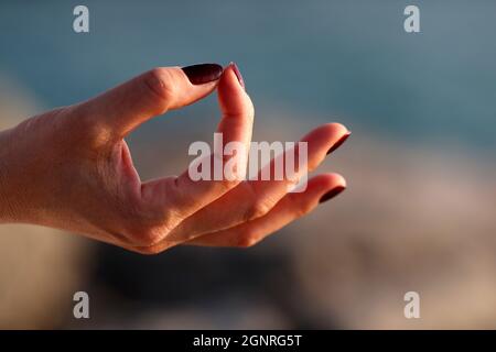 Nahaufnahme der Hand der jungen Frau, die in Lotusposition Meditation praktiziert. Yoga. Stockfoto