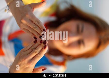 Nahaufnahme der Hände einer jungen Frau, die Meditation praktiziert. Stockfoto