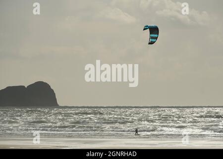 Gower, Swansea, Großbritannien. September 2021. UK Wetter: Ein windiger Herbsttag mit Sonnenschein und Schauern am Llangennith Beach auf der Gower Halbinsel. Ein Kite-Surfer nutzt die steife Onshore-Brise. Das Vorgebirge Worms Head ist im Hintergrund bei Rhossili Bay abgebildet. Kredit: Gareth Llewelyn/Alamy Live Nachrichten Stockfoto