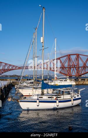 Die Yachten liegen im Hafen von South Queensferry vor dem Hintergrund der Forth Rail Bridge - South Queensferry, Schottland, Großbritannien Stockfoto