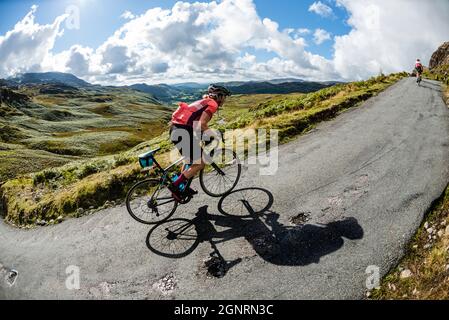 Rennradfahrer klettern 33% Steigung in der Fred Whitton Challenge, Hardknott Pass, Cumbria. Stockfoto