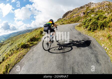 Rennradfahrer klettern 33% Steigung in der Fred Whitton Challenge, Hardknott Pass, Cumbria. Stockfoto