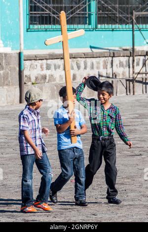 SANTIAGO ATITLAN, GUATEMALA - 24. MÄRZ 2016: Kleine Jungen mit Kreuz in Santiago Atitlan. Stockfoto