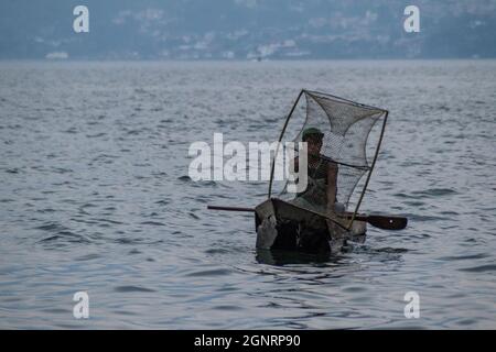 SAN MARCOS LA LAGUNA, GUATEMALA - 24. MÄRZ 2016: Fischer auf traditionellen Holzbooten auf dem Atitlan See in der Nähe des Dorfes San Marcos La Laguna. Stockfoto