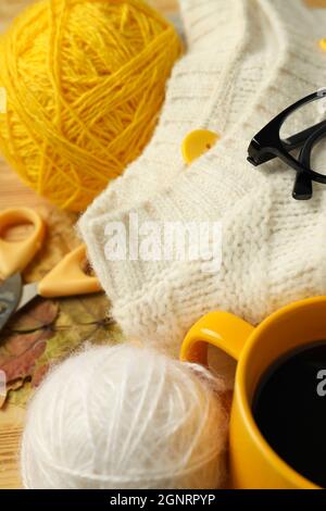 Konzept des Strickens mit Garnkugeln auf Holztisch, Nahaufnahme. Stockfoto