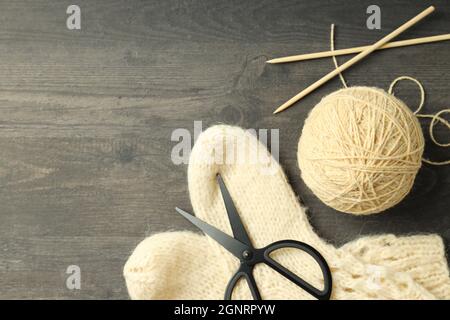 Konzept des Strickens mit Garnkugel auf grauem Holztisch Stockfoto