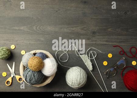 Konzept des Strickens mit Garnkugeln auf grauem Holztisch Stockfoto