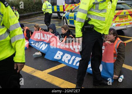 Colnbrook, Großbritannien. September 2021. Britische Klimaaktivisten blockieren eine Zufahrtsstraße von der M25 an der Anschlussstelle 14 in der Nähe des Flughafens Heathrow als Teil einer Kampagne, die die britische Regierung dazu bewegen sollte, erhebliche Gesetzesänderungen vorzunehmen, um die Emissionen zu senken. Die Aktivisten fordern, dass die Regierung unverzüglich verspricht, sowohl die vollständige Finanzierung und Isolierung des gesamten sozialen Wohnungsbaus in Großbritannien bis 2025 sicherzustellen, als auch innerhalb von vier Monaten einen rechtsverbindlichen nationalen Plan zur vollständigen Finanzierung und Sicherstellung der vollständigen energiesparenden und kohlenstoffarmen Nachrüstung des gesamten Hauses zu erstellen, Ohne externe Kosten, Stockfoto