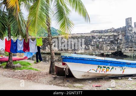 PORTOBELO, PANAMA - 28. MAI 2016: Trockenwäsche und ein Fischerboot in Portobelo Dorf, Panama Stockfoto