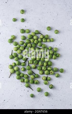 putenbeere, auch Wildaubergine oder Erbsenaugpflanze genannt, rundes Gemüse auf einem strukturierten weißen Hintergrund Stockfoto