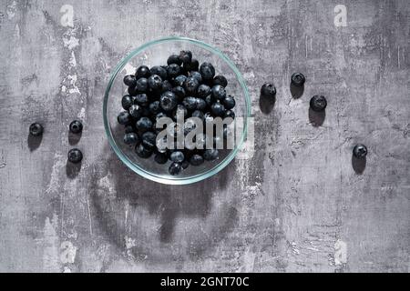 Heidelbeeren in einer Glasplatte auf dunklem Hintergrund Stockfoto