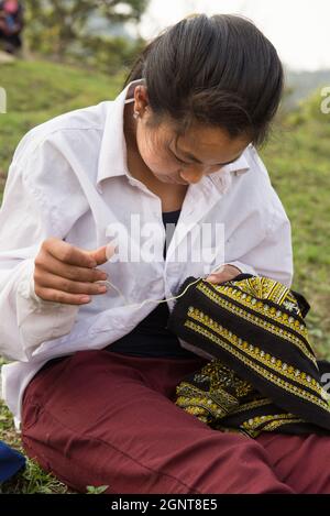 Sapa, Vietnam - 14. April 2016: Junge vietnamesin im Dorf in der Nähe von Sapa macht Handarbeit. Schwarze Hmong Minderheit weibliche Stich im Freien. Stockfoto