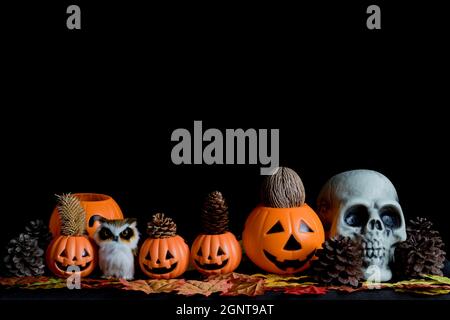 Halloween Totenkopf, Halloween Kürbisse auf einem alten Holztisch vor schwarzem Hintergrund mit Platz für Text. Halloween-Konzepte. Happy Hall Stockfoto