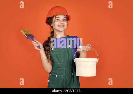 Fröhliche Kinderarbeiter mit Gebäude Uniform und Malerei Eimer und Pinsel, kreative Arbeit Stockfoto