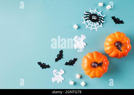 Halloween verziert mit kleinen Kürbissen Papier Geister und Spinnen auf türkis Stockfoto