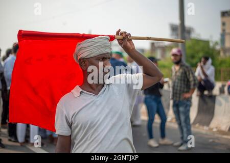 Ghaziabad, Indien. September 2021. Während eines landesweiten Streiks gegen die Agrarreformen an der Grenze zwischen Delhi und Uttar Pradesh hält ein Landwirt eine Flagge.Tausende indische Bauern blockierten den Verkehr auf wichtigen Straßen und Eisenbahnlinien an mehreren Stellen ab dem Morgen, als die von der Samyukta Kisan Morcha (Bauerngewerkschaft) eingeleitete Schließung, Ein Dachverband von 40 Bauerngewerkschaften begann, die Blockade wurde um 4 Uhr aufgehoben. Kredit: SOPA Images Limited/Alamy Live Nachrichten Stockfoto