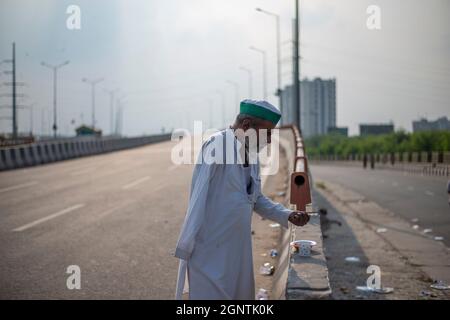 Ghaziabad, Indien. September 2021. Während eines landesweiten Streiks gegen die Agrarreformen an der Grenze zwischen Delhi und Uttar Pradesh sah der Landwirt, wie er auf einer verlassenen Straße aß.Tausende indische Bauern blockierten den Verkehr auf Hauptstraßen und Eisenbahnlinien an mehreren Orten von morgens an, als die von der Samyukta Kisan Morcha (Bauerngewerkschaft) eingeleitete Schließung, Ein Dachverband von 40 Bauerngewerkschaften begann, die Blockade wurde um 4 Uhr aufgehoben. Kredit: SOPA Images Limited/Alamy Live Nachrichten Stockfoto