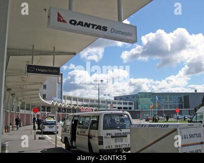 Außenansicht des Inlandsterminals des Auckland International Airport mit Qantas Domestic- und Origin Pacific-Schildern vom Überhang im September 2004. Stockfoto