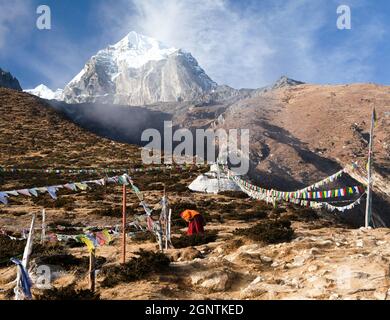 Buddhistischer Mönch, Stupa und Gebetsfahnen in der Nähe des Pangboche-Klosters und des Tabuche-Gipfels, Leben im Khumbu-Tal auf dem Weg zum Everest-Basislager in nepal Stockfoto