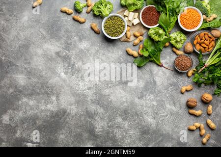 Protein für Vegetarier: Tofu, Gemüse, Nüsse, Samen und Hülsenfrüchte Draufsicht auf einem konkreten Hintergrund. Konzept: Gesunde, saubere Lebensmittel. Stockfoto