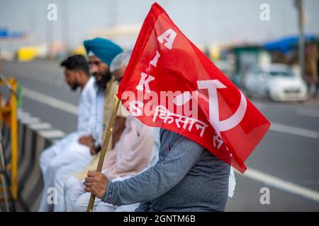 Ghaziabad, Indien. September 2021. Während eines landesweiten Streiks gegen die Agrarreformen an der Grenze zwischen Delhi und Uttar Pradesh hält ein Landwirt eine Flagge.Tausende indische Bauern blockierten den Verkehr auf wichtigen Straßen und Eisenbahnlinien an mehreren Stellen ab dem Morgen, als die von der Samyukta Kisan Morcha (Bauerngewerkschaft) eingeleitete Schließung, Ein Dachverband von 40 Bauerngewerkschaften begann, die Blockade wurde um 4 Uhr aufgehoben. (Foto von Pradeep Gaur/SOPA Images/Sipa USA) Quelle: SIPA USA/Alamy Live News Stockfoto