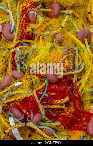 Bunte Fischernetze am Kai eines Hafens in zakynthos griechenland. Farbige Netze, die zum Fischen mit Fängen und Seilen verwendet werden. Stockfoto