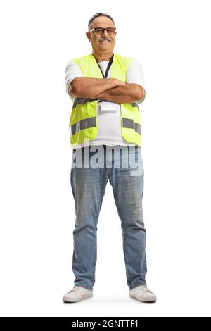 In voller Länge Porträt eines lächelnden reifen Mannes, der eine reflektierende Weste trägt und mit gekreuzten Armen auf weißem Hintergrund isoliert posiert Stockfoto