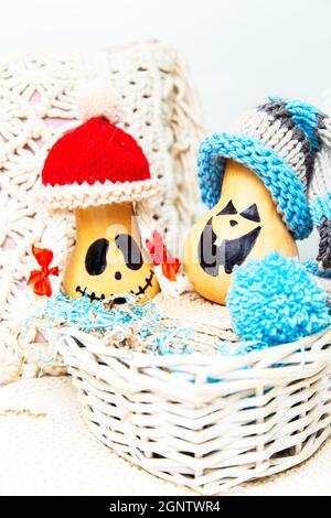 Zwei lustige Kürbisse in Kappen in einem Korb. Jacks Laternen. Ungewöhnliches Halloween, Humor. Stockfoto