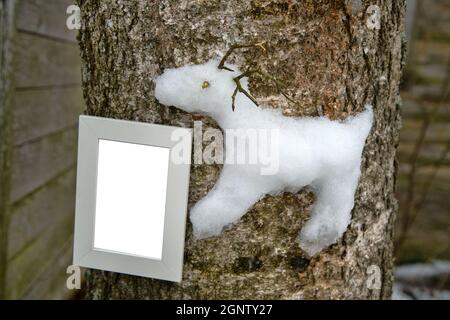 Kreativer Ansatz für Kinder. Die Kinder steckten eine Schneegarantie eines nördlichen Rentiers auf einen Baum (wie ein Hochrelief). Holzrahmen mit Buchstaben Stockfoto