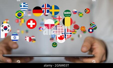 3d-Darstellung der Weltkarte mit allen Staaten und ihren Flaggen auf einem Tablet, das von einem Mann gehalten wird Stockfoto