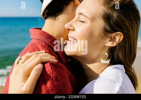 Glückliches Paar, das sich am Strand umarmte Stockfoto
