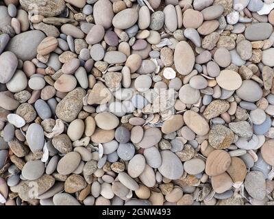 Bunte, Glatte Küstenstrandfelsen Und Kieselsteine Stockfoto