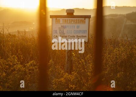 Los Angeles, Kalifornien, USA. 30. Dezember 2015. No Trespassing Zeichen und Zaun markieren die Grenze des SoCalGas Aliso Canyon Lagers, Blick in Richtung wo eine undichte Gas gut und ein Relief gut gebohrt werden, an der Spitze von einem öffentlichen Wanderweg von Bee Canyon Park als Methan-Gas Leckagen an die Lagerstätte SoCalGas Aliso Canyon gut SS-25 im Stadtteil Porter Ranch in Los Angeles , Kalifornien am Mittwoch, 30. Dezember 2015. Die Aliso Canyon-Gas-Leck (auch Porter Ranch Gasleck genannt) war eine massive Natural Gas-Leck, die am 23. Oktober 2015 begonnen. Nach Wik Stockfoto