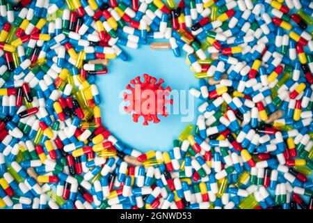Studien zur Einführung von Anti-Covid-Pillen zur Bekämpfung des Virus. Modell des Virus von verschiedenen Pillen umgeben. Gesundheitskonzept. Selektive Fokuspunkte Stockfoto
