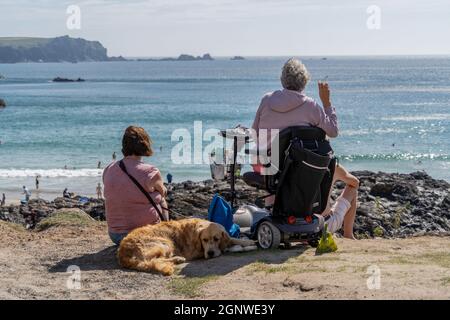 Penzance, Großbritannien. September 2021. Eine ältere Dame genießt eine Zigarette und schaut auf die Küste von Kynance Cove in Cornwall. Kynance Cove ist ein beliebtes Urlaubsziel in Cornwall. Die Bucht bietet klares blaues Wasser und weichen weißen Sand. Jedes Jahr kommen Zehntausende in diesen abgelegenen Teil von Cornwall, um Kynance Cove zu sehen und im blauen Wasser zu schwimmen. (Foto von Edward Crawford/SOPA Images/Sipa USA) Quelle: SIPA USA/Alamy Live News Stockfoto