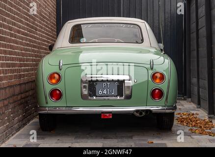 OSS, Nordbrabant, Niederlande, 25.09.2021, Rückansicht eines geparkten alten Zeitschaltwagens Nissan Figaro aus dem Jahr 1991 in Grün Stockfoto