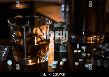 Geld, Pillen, Drogen und ein Glas Single Malt Whiskey Konzept schlechte Gewohnheiten, sucht Stockfoto