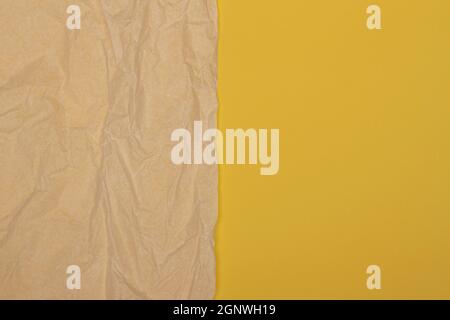 Beigefarbenes altes, faltiges Papierblatt auf gelbem Hintergrund. Draufsicht, Platz für Text kopieren Stockfoto