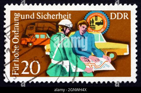 DDR - UM 1975: Eine in der DDR gedruckte Briefmarke zeigt Polizisten, die helfen, Autofahrer, Verkehrspolizei, die der Öffentlichkeit dienen und unterweisen, um 1975 Stockfoto