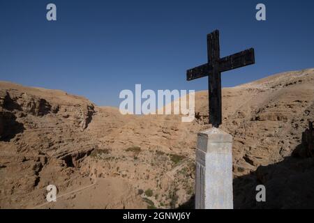 Ein eisernes Kreuz auf einer Säule, auf dem Weg zum kloster des heiligen georg in der Wüste Judäa, Israel. Stockfoto