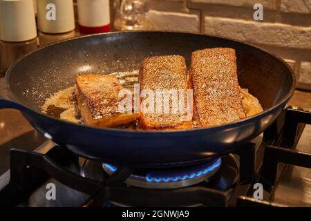 Frische Filets von Salomonen werden in einer Pfanne auf einem Gasherd gebraten Stockfoto
