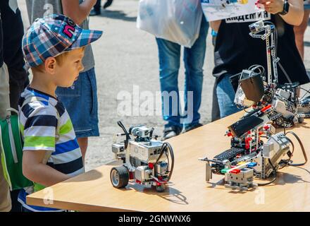 Zaporizhia, Ukraine- 19. Juni 2021: Charity Family Festival: Boy exploring robots at Outdoor modern Technologies Exhibition. Stockfoto