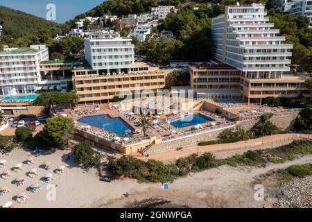 Luftaufnahme der spanischen Insel Ibiza mit der wunderschönen Strandpromenade und den Hotels und Menschen am und am Strand von Cala Llonga im Sommer Stockfoto